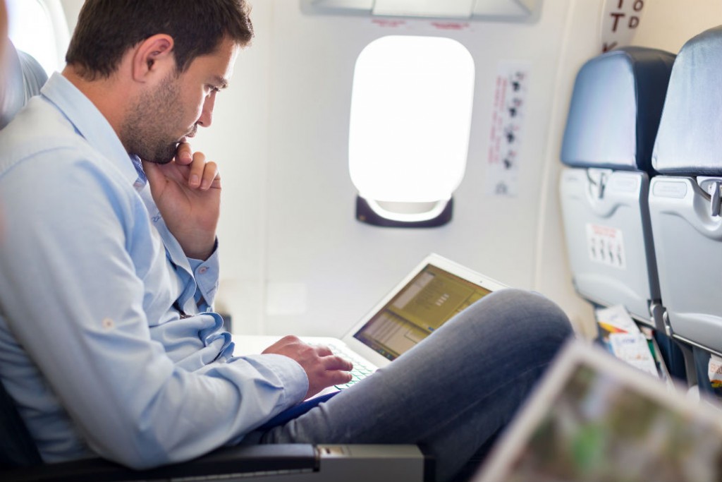 Businessman working with laptop on airplane